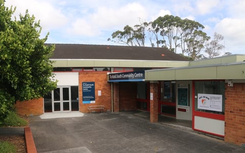 Single-storey brick community centre with covered entry, ramp, and signage