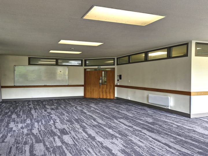 Meeting room with carpet, whiteboard, timber doors and highlight windows