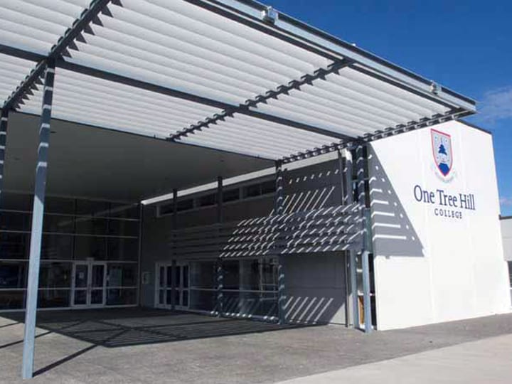 School building exterior with a covered entrance walkway and branded signage