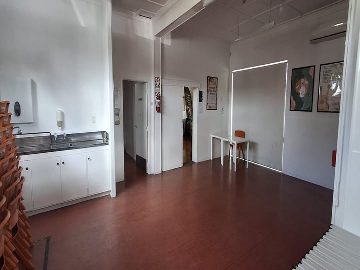 Hall interior with sink bench, fire extinguisher and event posters on wall