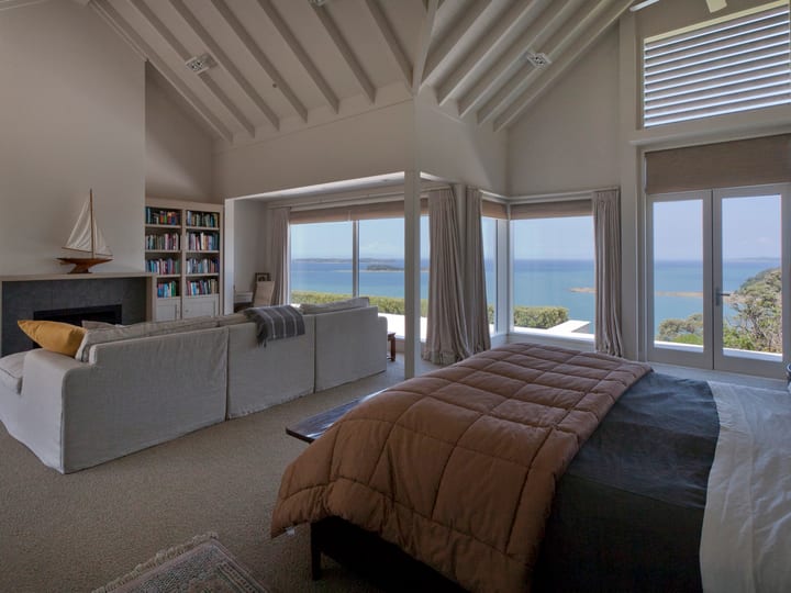 Master bedroom with vaulted ceiling, sea view and bookshelf sitting area