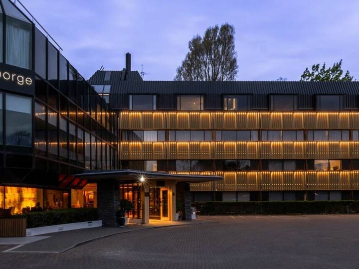 Multi-storey hotel building illuminated at dusk with warm interior lighting
