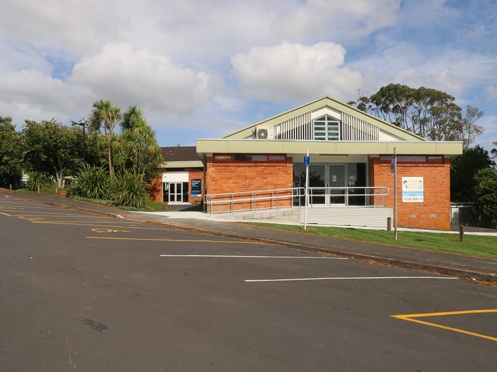 Single-storey brick building with car park in foreground and accessible ramp entry