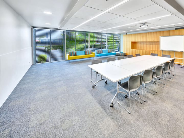 Meeting room with long table, chairs, whiteboard and timber wall panels