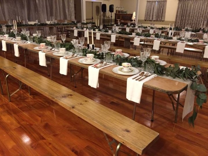 Empty polished timber-floor hall with raised platform at the far end