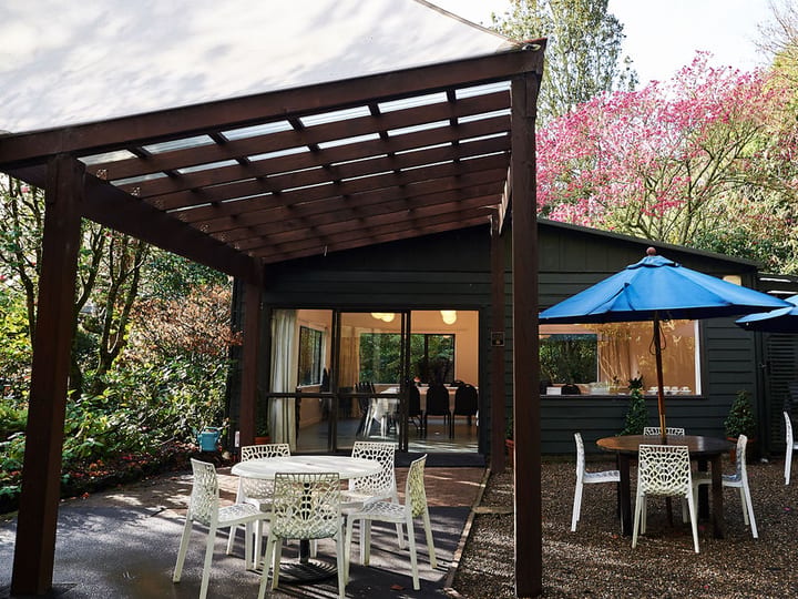Timber-clad hall with long tables, globe pendant lights and vaulted ceiling