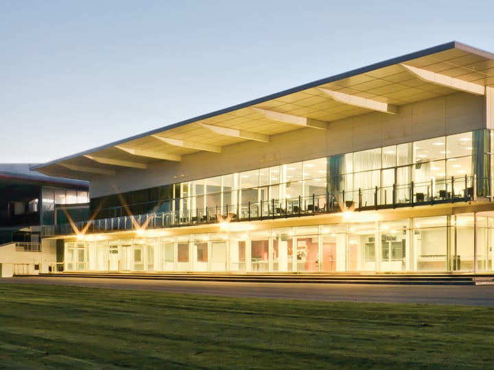 Large modern function centre building with full-length glazing, illuminated at dusk