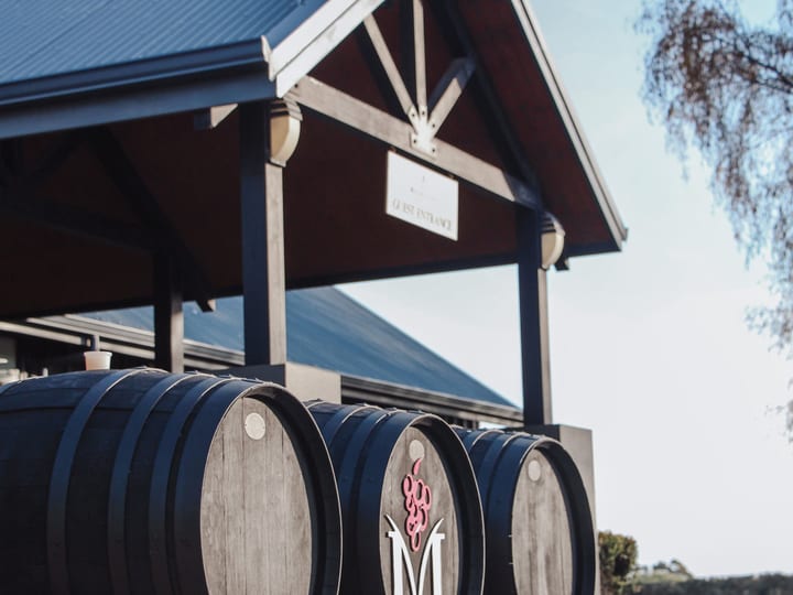 Winery entrance with large barrels and pavilion structure
