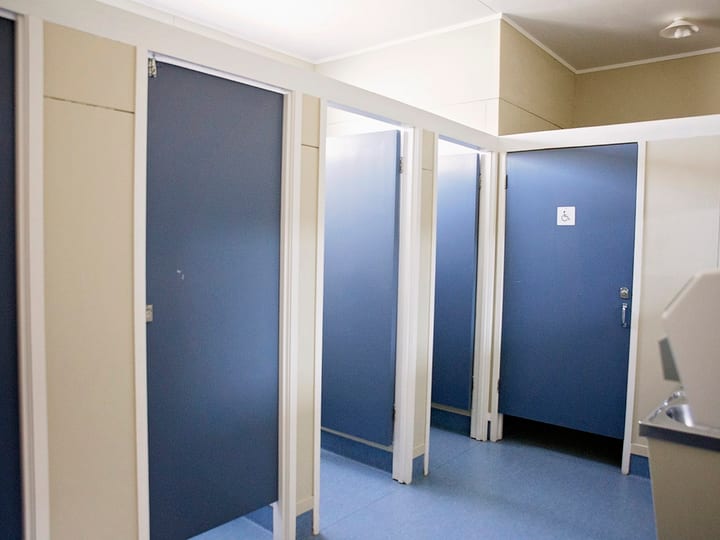 Accessible toilet block with blue cubicle doors