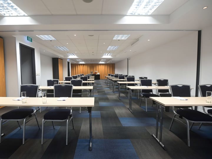 Conference room with classroom table rows and timber feature wall