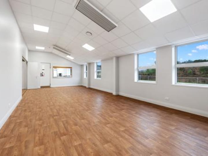 Plain empty room with timber floor and kitchen servery window
