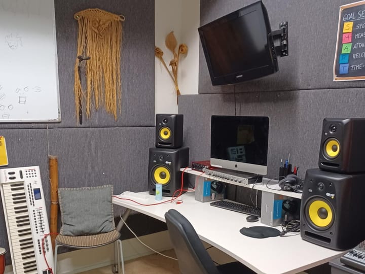 Recording studio desk with monitor speakers, computer, and mixing equipment