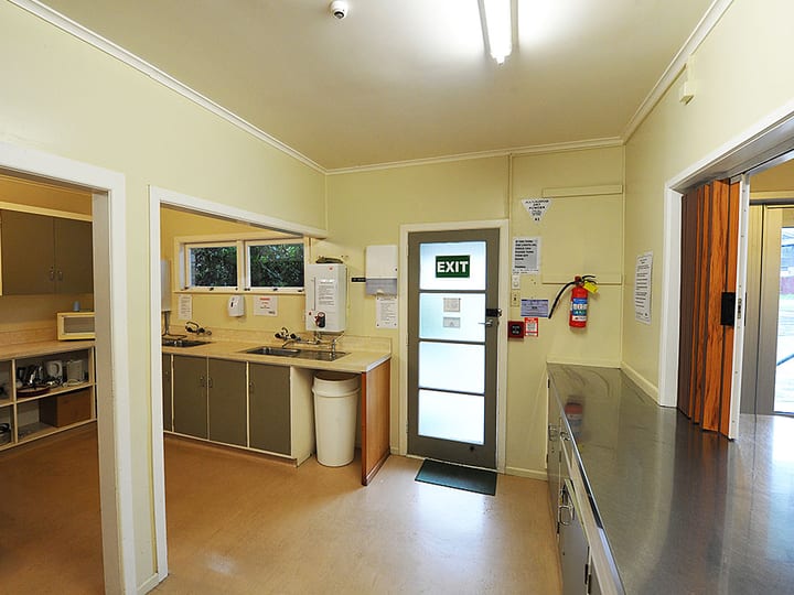 Hall kitchen area with sink, benches and door to exterior