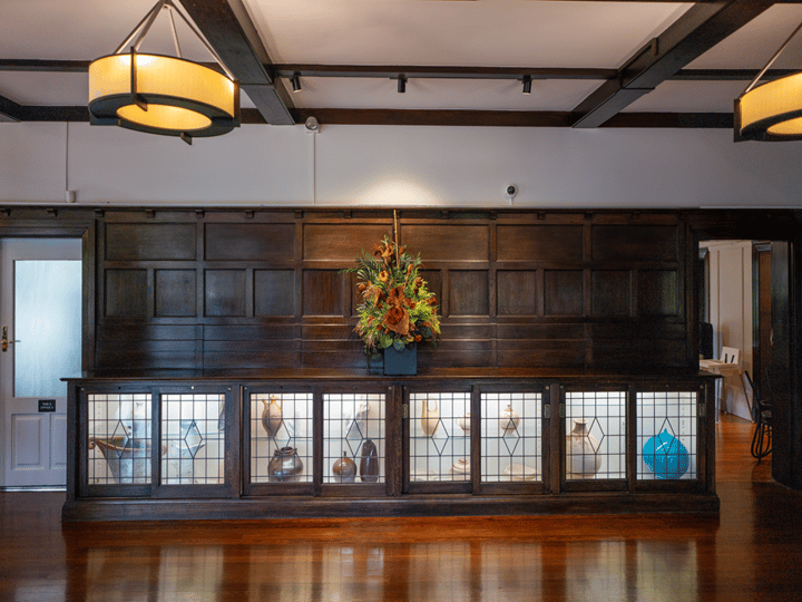 Dark timber cabinet with stained glass doors and floral display on top