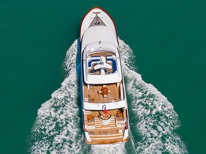 Aerial view of motor yacht underway in turquoise water