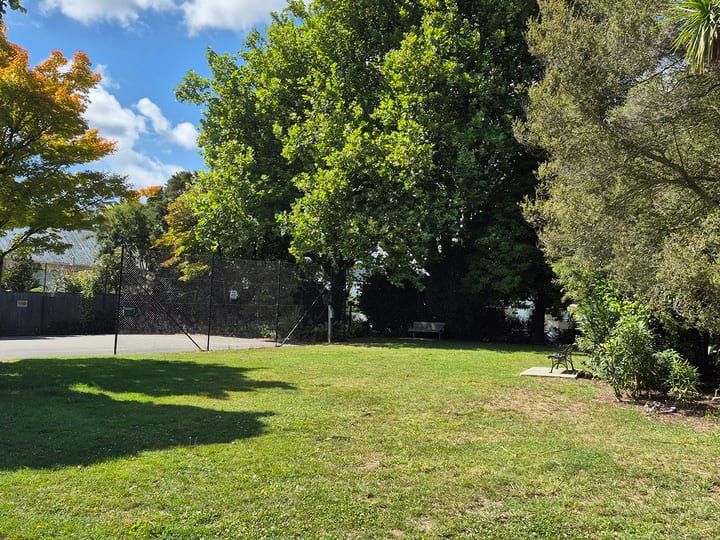 Open grassed reserve with trees and garden planting