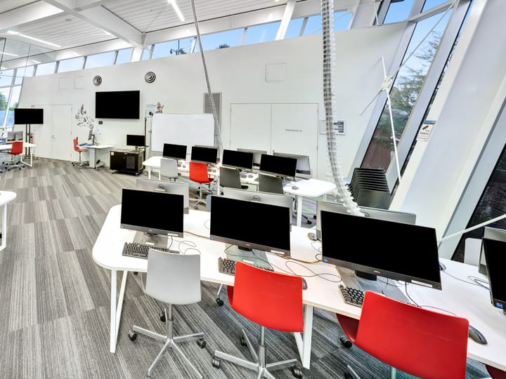 Open-plan workspace with computer workstations and red chairs