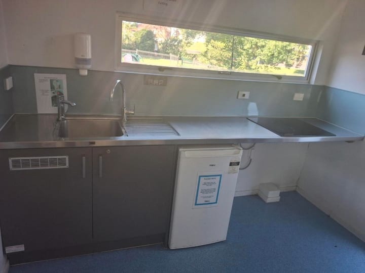 Small kitchenette bench with sink, microwave and under-bench fridge