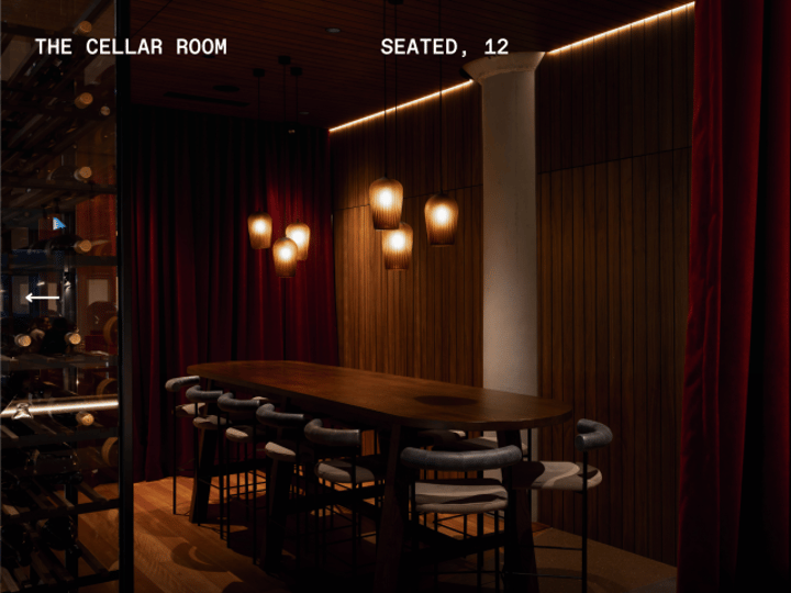 Intimate private dining room with long table, pendant lights and red curtains