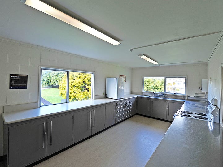 Hall kitchen with grey benchtops, stove and refrigerator
