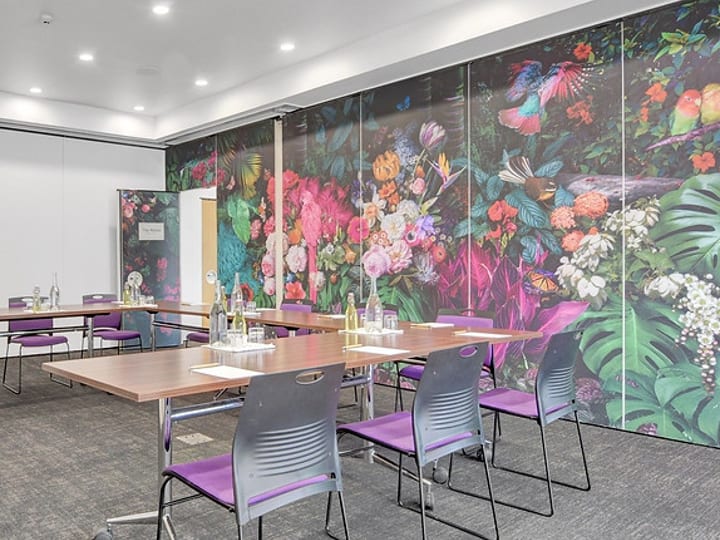 Meeting room with tables, chairs, and bold floral wallpaper mural