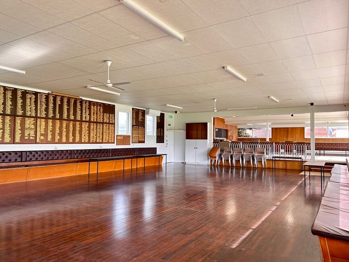 Bright open room with carpet, bench seating, large windows and membership boards