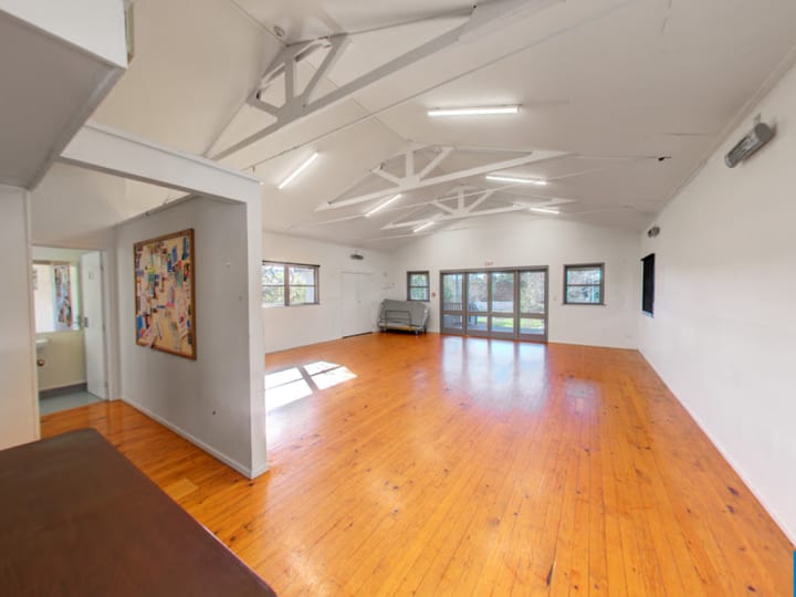 Open hall interior with exposed timber roof trusses and polished timber floor