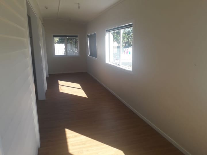 Narrow room with timber floor and windows along one wall