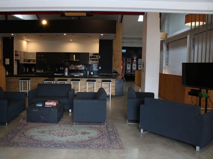 Open-plan interior with sofas, bar, and kitchen area