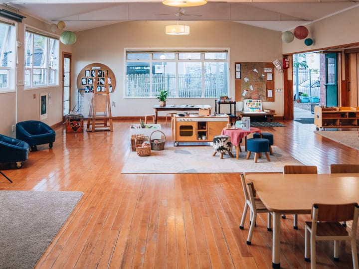 Church hall interior with timber floor, vaulted ceiling, and toy equipment set up for a playgroup