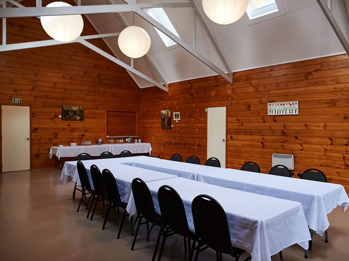 Garden meeting room with U-shape table setup, garden-view windows and projector screen