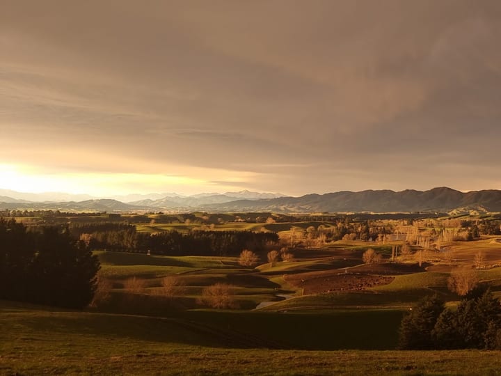 Rolling hills and farmland panorama at dusk with dramatic clouds
