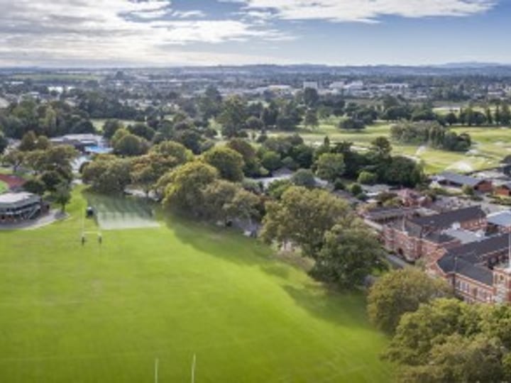 Aerial view of college campus with red-brick buildings, lawns and playing fields