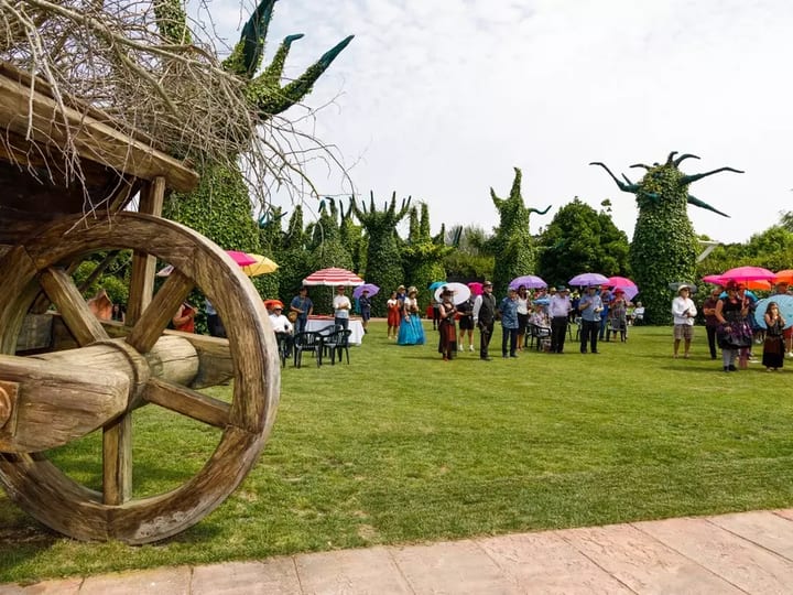 Garden area with sculptural topiary and visitors gathered on lawn