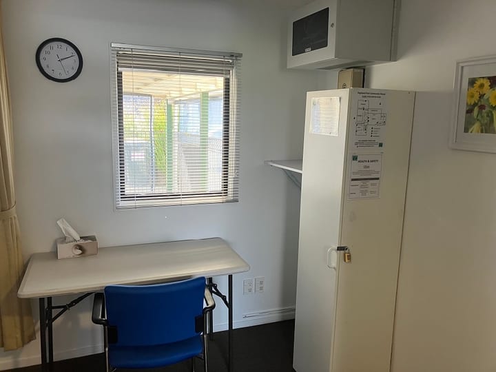 Small room with desk, blue chair and wall-mounted cabinet