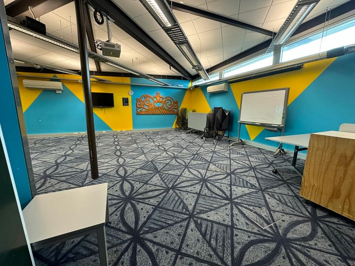 Room with blue and yellow walls, patterned carpet and carved wooden panel