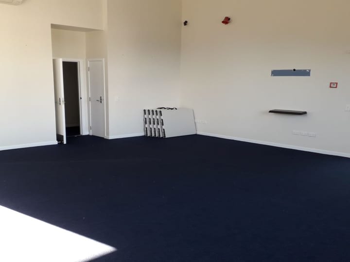 Empty room with dark carpet and exit door to garden