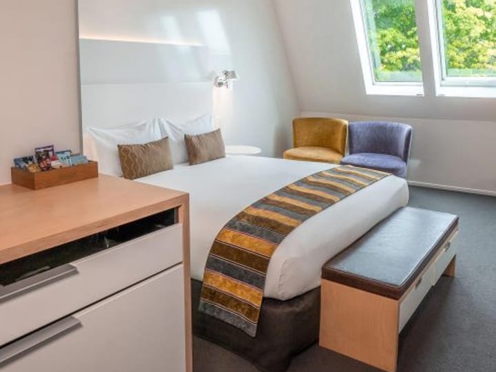 Hotel room with double bed, skylights and armchairs
