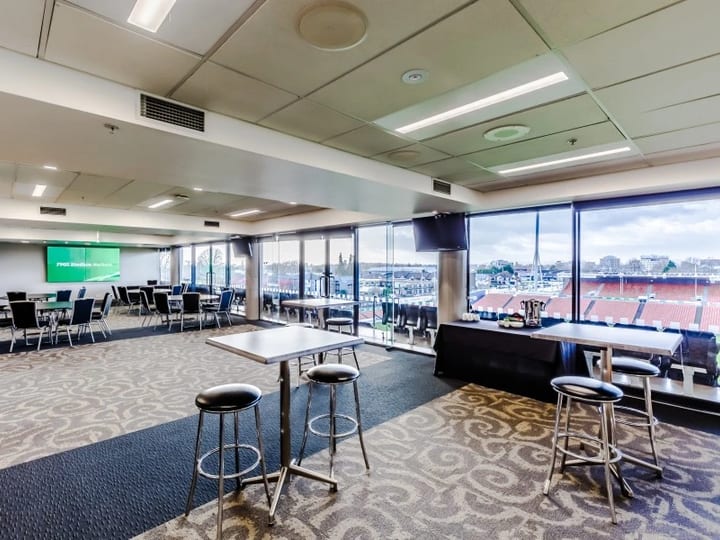 Stadium lounge with cocktail tables, bar stools and pitch views