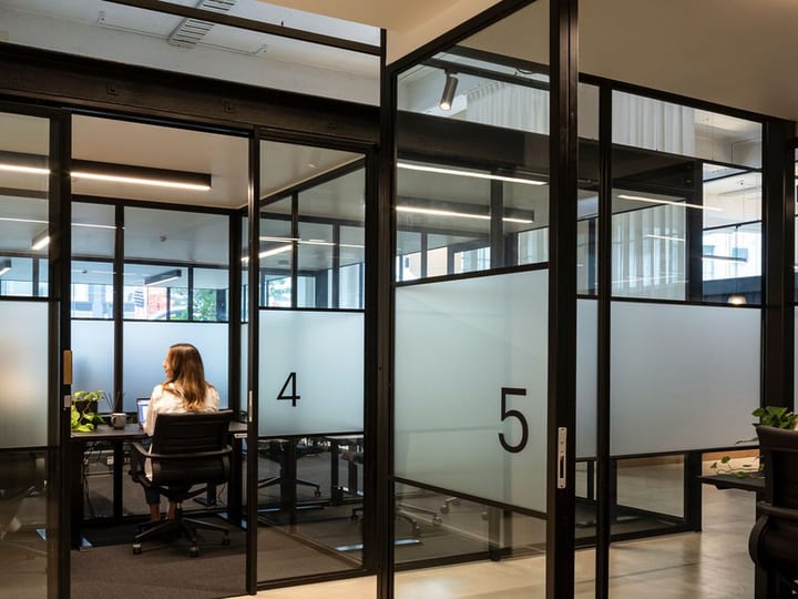 Glass-partitioned meeting rooms numbered four and five with people seated inside
