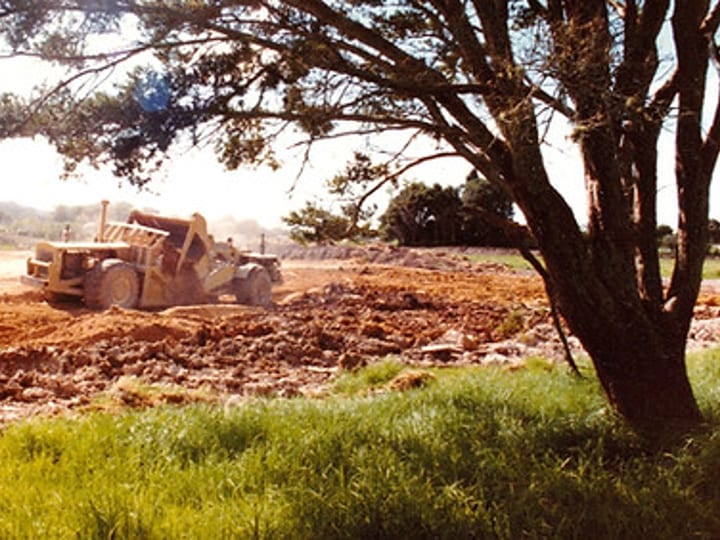 Earthworks and grading of sports grounds with trees and machinery