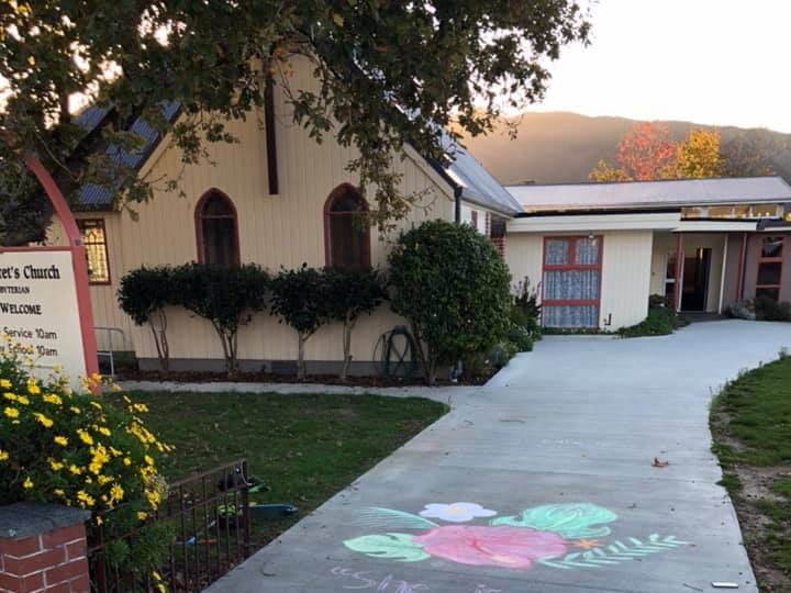 Church exterior showing chalk art on driveway with Mother's Day message