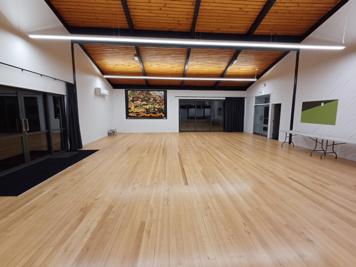 Hall with timber ceiling, wooden floor and artwork on white walls