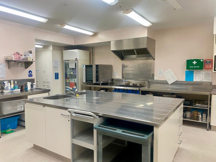 Commercial kitchen with stainless steel benchtops, central island, and catering equipment