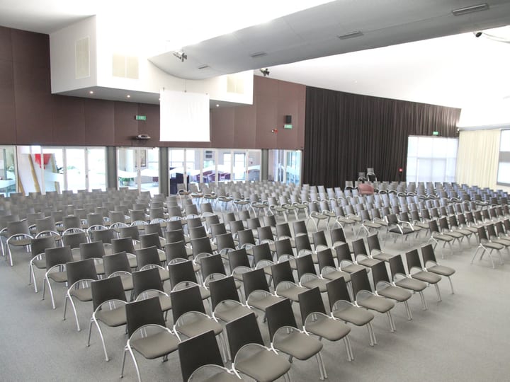 Large auditorium with rows of chairs and raised platform