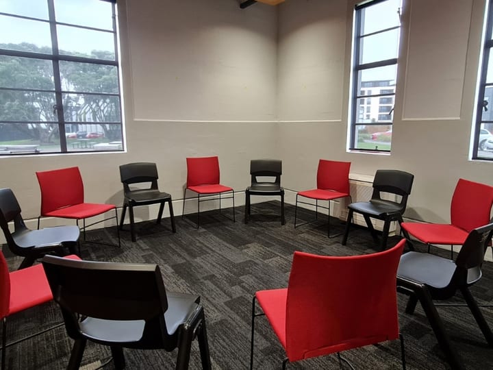 Small room with chairs in a circle and windows on two walls