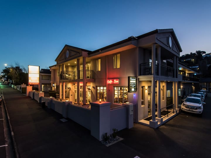 Two-storey motel building with balconies illuminated at night