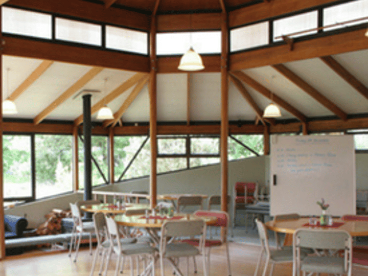 Octagonal timber meeting room with tables, chairs, and whiteboards, labelled Meeting spaces