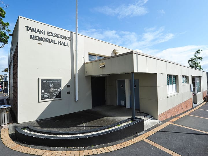 Single-storey hall building exterior with signage and car park