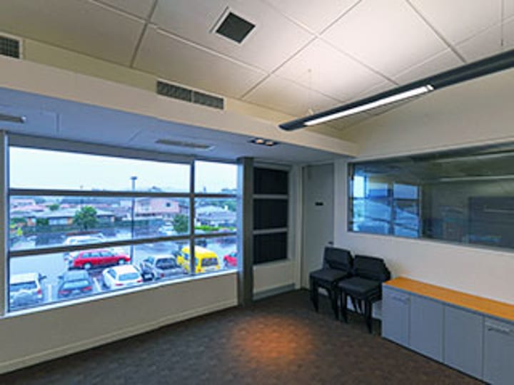 Small room with small table, chairs and window overlooking car park